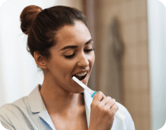 Woman using oral care device at home